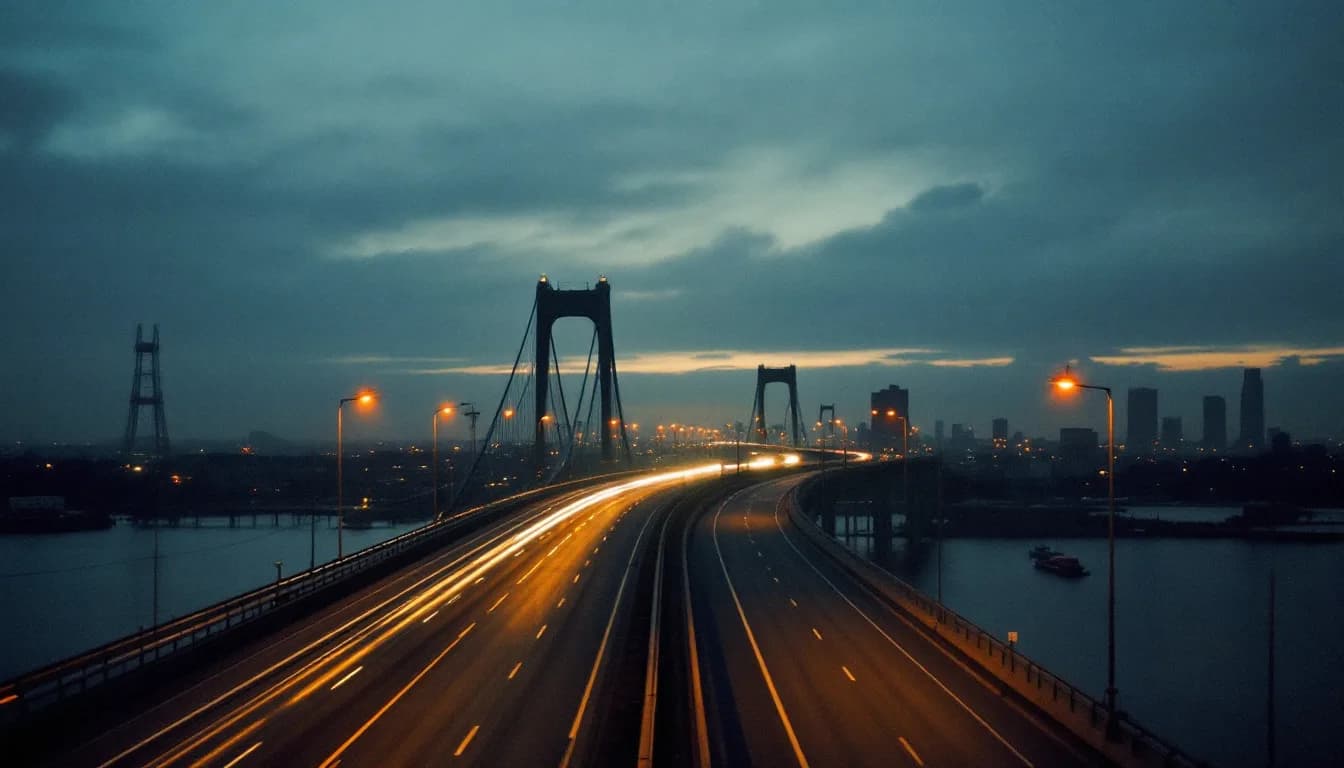 A suspension bridge seen from an empty expressway approach at sunrise